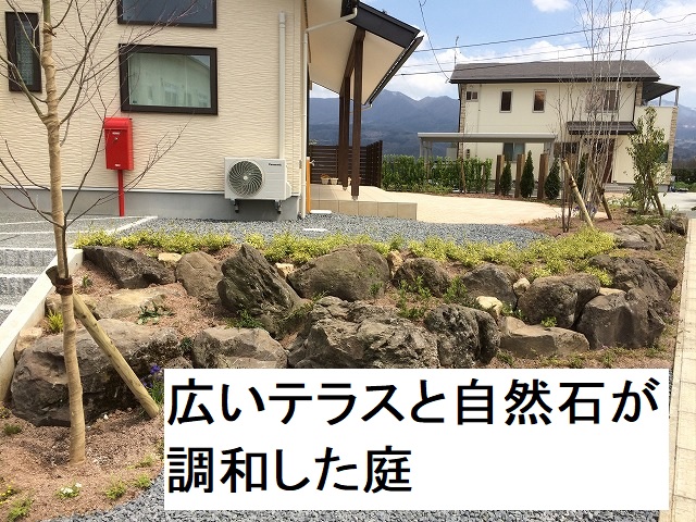 広いテラスと自然石が調和した庭
